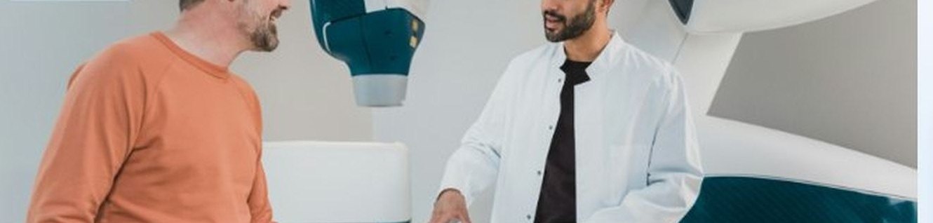 A patient talking with a doctor beside imaging equipment