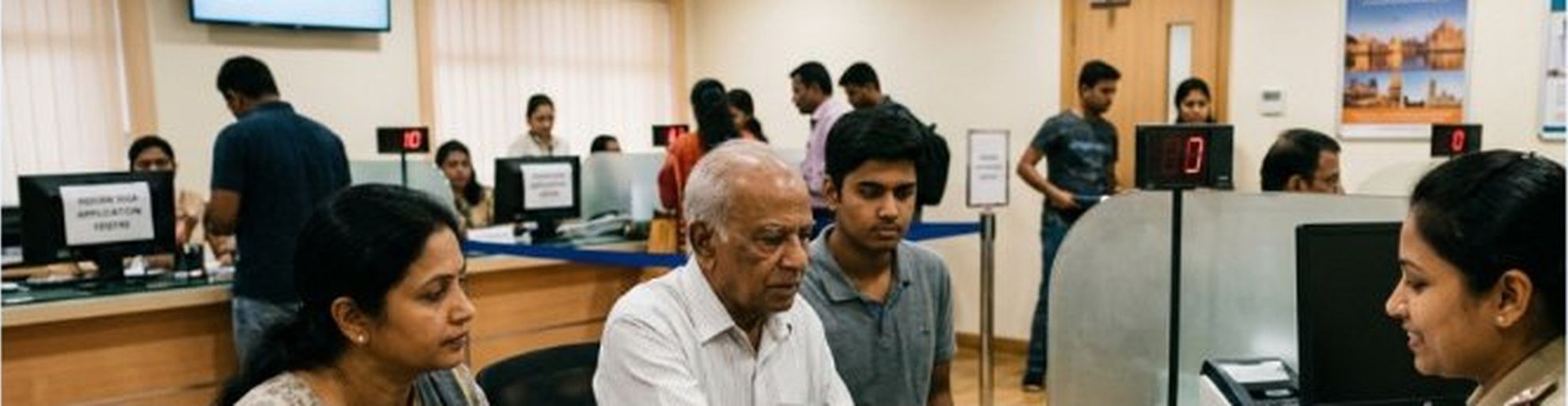 A family being assisted at an Indian visa application centre counter